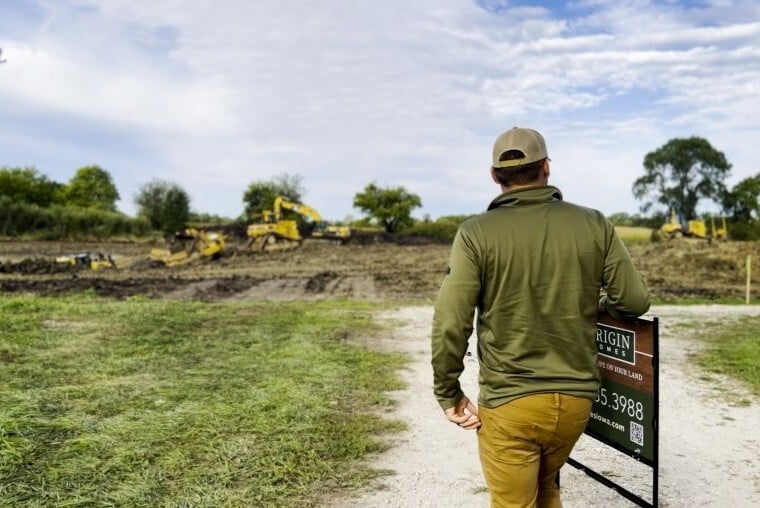 Iowa builder reviewing custom home site at a rural construction site