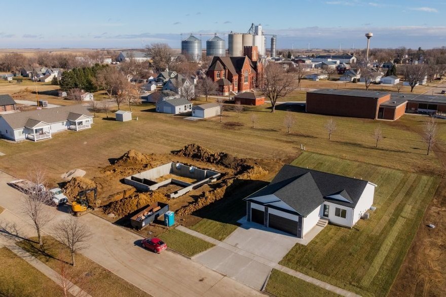 Aerial view of a custom ranch-style home on a lot in town in Templeton, Iowa